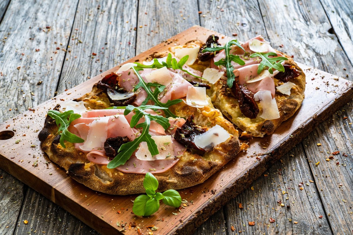 Pinsa ovale topped with prosciutto cotto, sun-dried tomatoes and rocket