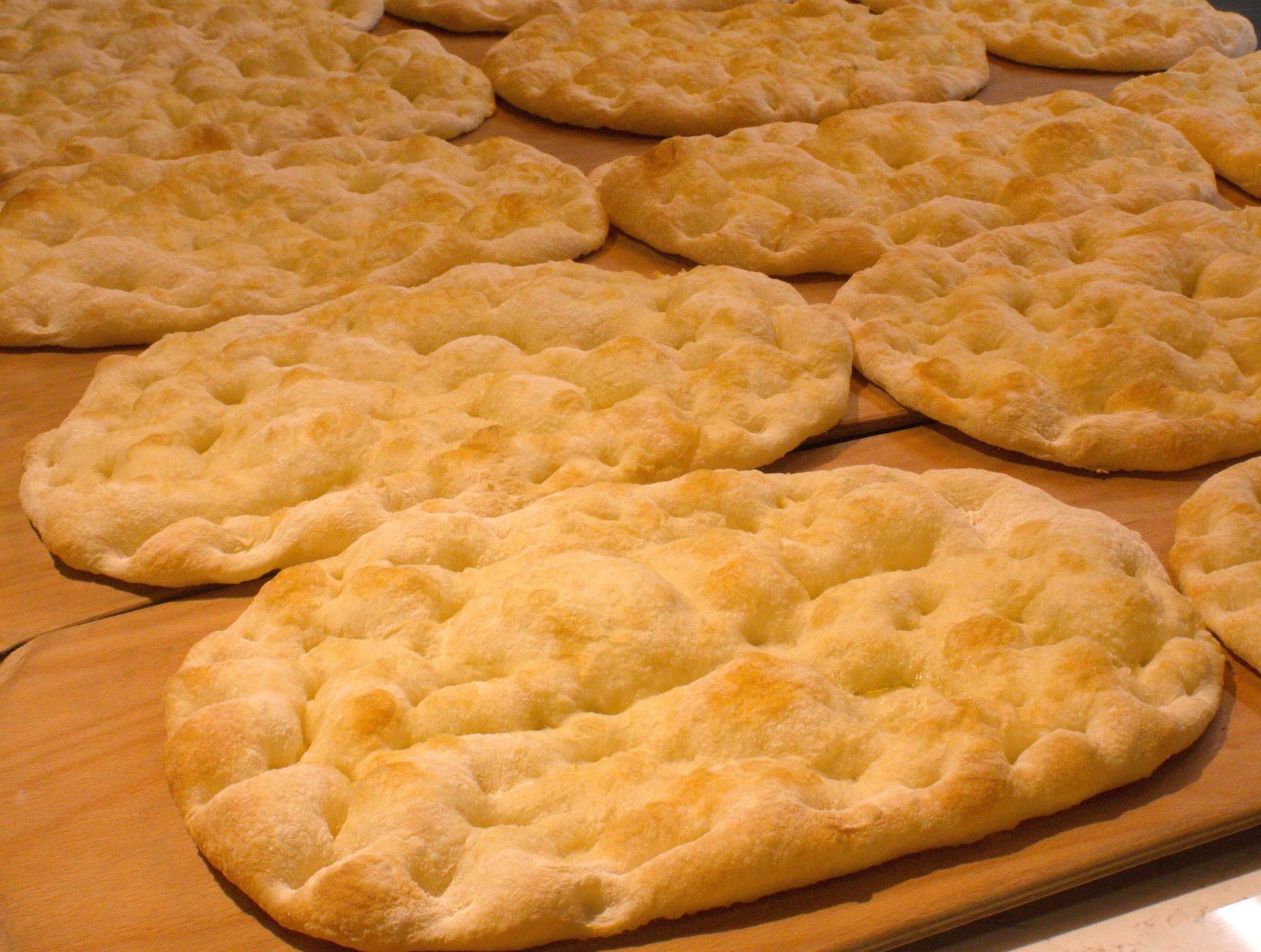 Rows of freshly baked pinsa bases ready for packing