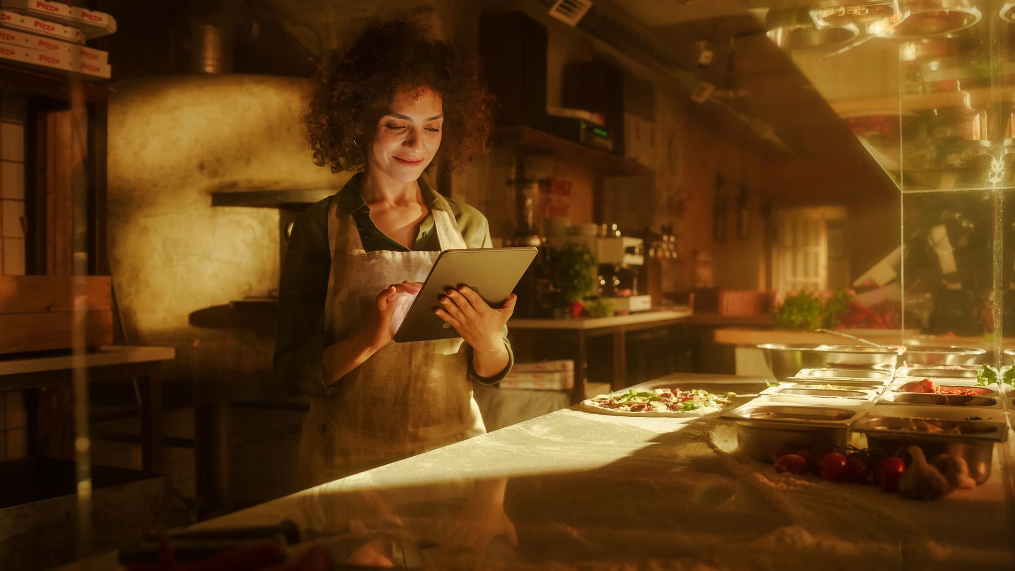 Chef checking orders on a tablet in a professional kitchen